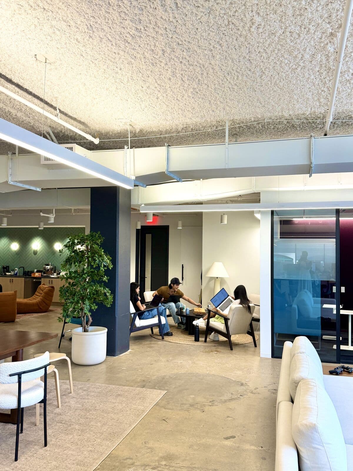 The Codes Health office in use: café, seating area, dining table, and living room sectional in one frame