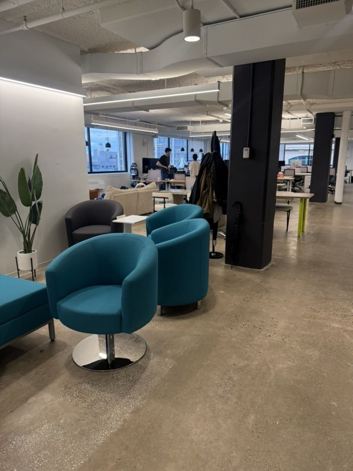 The entrance area on move-in day: empty floor with a few leftover teal chairs and a coat rack